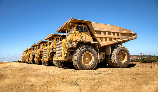Large dump trucks in a row at a construction site