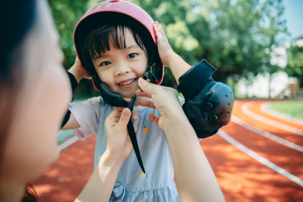 istock Asian mother help daughter put on hard hat, family time 1418922103
