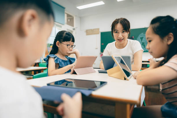 istock Asian Chinese female teacher using digital tablet for multimedia teaching 1418923379