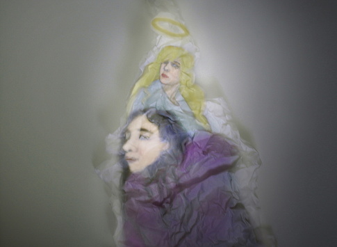 Photo crumpled paper in the shape of a girl and an angel behind her back