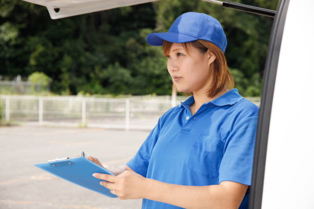 istock Moving or delivery driver woman. Organizing, recording, and taking notes on slips. 1418926163