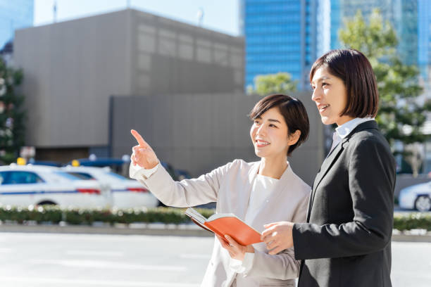 istock A woman looking at a notebook with two people (business image) 1418926949