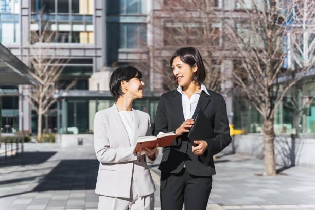 istock A woman looking at a notebook with two people (business image) 1418926961