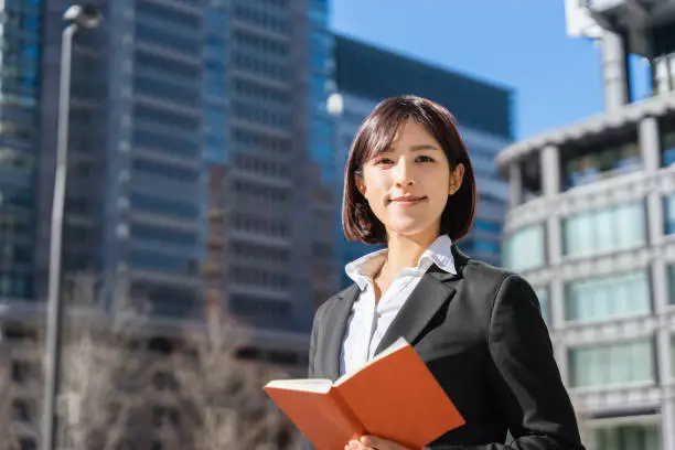 woman holding a notebook and looking into the distance