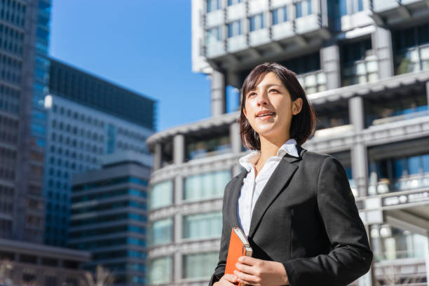 istock woman holding a notebook and looking into the distance 1418927037
