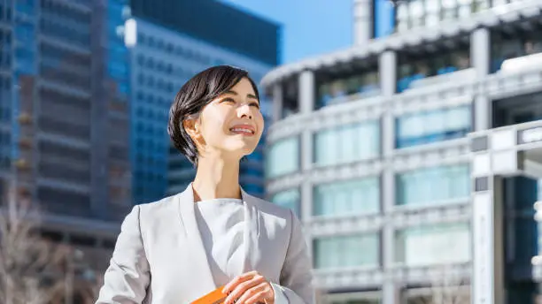 woman holding a notebook and looking into the distance