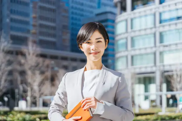 woman holding a notebook and looking into the distance