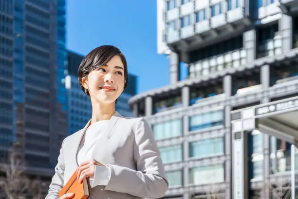 woman holding a notebook and looking into the distance