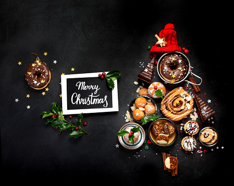 Christmas tree with sweets and cookies decoration on dark background. Holiday food. Top view