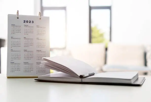2023 calendar and note pad on the desk.