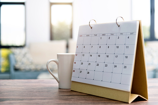 Calendar and cup on the table.
