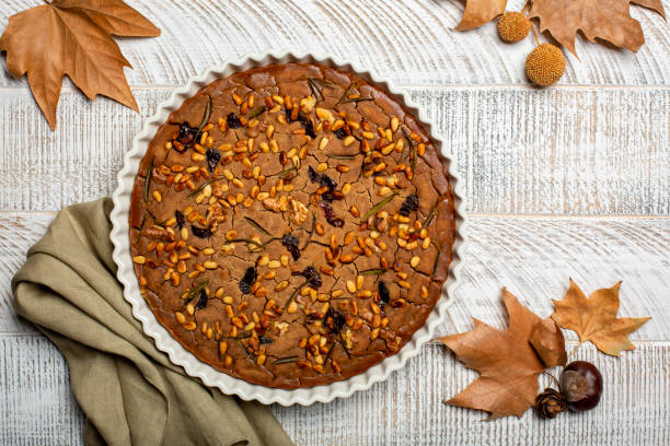 tuscan vegan autumn chestnut cake castagnaccio. made with water, olive oil, pine nuts, rosemary and raisins. homemade, without wheat flour. - castanhas imagens e fotografias de stock