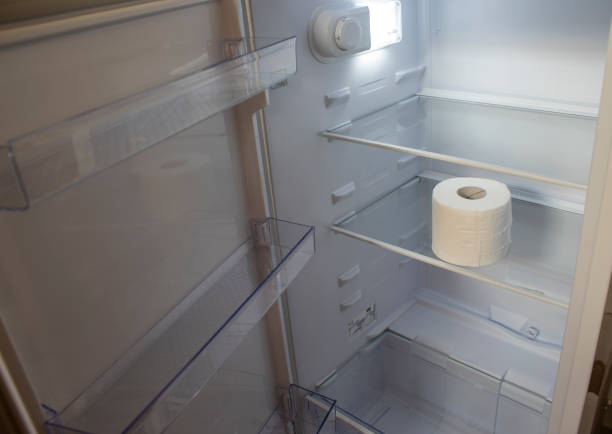 istock Empty Refrigerator. Toilet Paper in an Empty Refrigerator. White Open Refrigerator. 1418941666