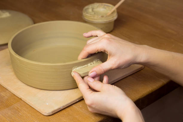 istock Woman ceramist attaching handle to the pot in pottery class. Potter workshop in ceramic studio 1418944065