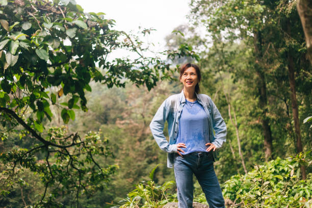 Portrait of Asian woman standing on tropical rainforest looking over scenic view
