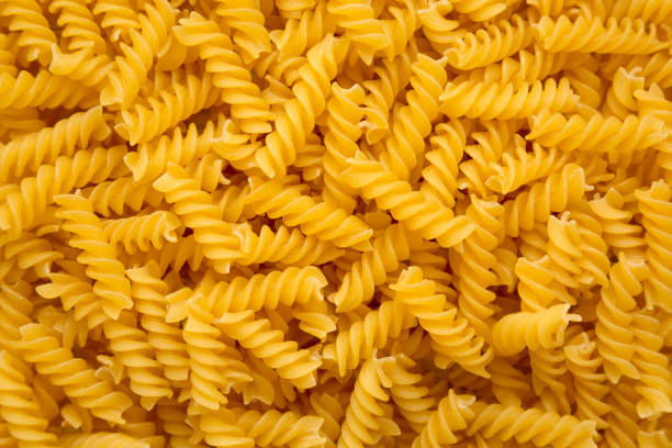 istock Uncooked Yellow Organic Rotini Pasta, view from above. Flat lay, top view, overhead. Closeup. 1418944709