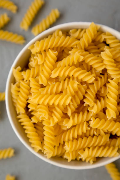 istock Uncooked Yellow Organic Rotini Pasta, top view. Flat lay, overhead, from above. 1418946620