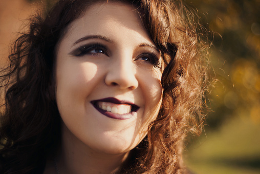 Young woman headshot portrait looking up and smiling widely
