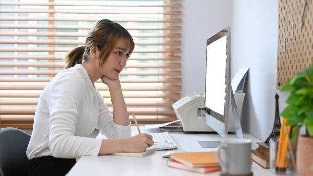 istock Focused woman freelancer working online with modern devices at her home office. 1418957087