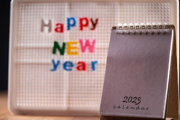 istock greeting 2023 ,desktop calendar on wooden table top 1418965815