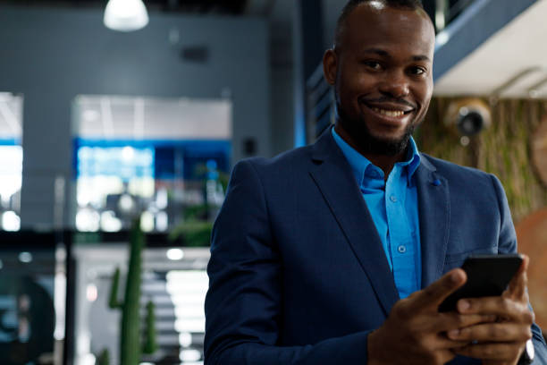 istock Happy businessman wearing suit using smartphone in office 1418967817