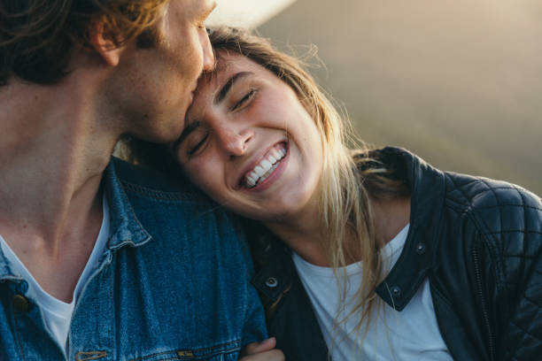 romantic boyfriend kissing on happy girlfriend's forehead - romantic stockfoto's en -beelden