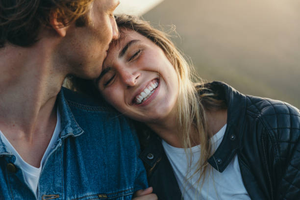 romantic boyfriend kissing on happy girlfriend's forehead - partnerskap bildbanksfoton och bilder