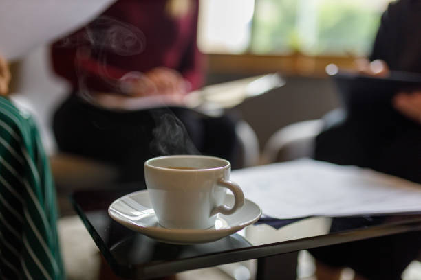 Close-up of coffee cup with saucer on table in office