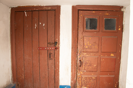 Two red old doors in the entrance of a residential building in Ukraine, the building and the interior of the house