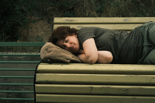 istock Woman is sleeping on the bench 1418973144