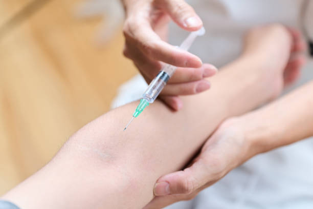 istock Asian doctor making an injection in his arm 1418975563