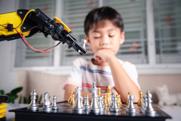 istock Asian little boy thinking and wait robot arm playing chess 1418976228