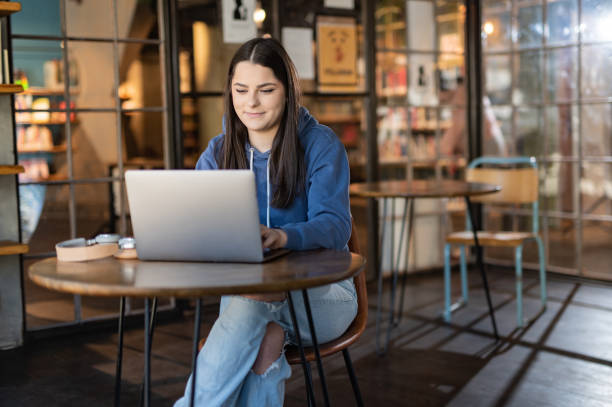 istock Female student using laptop in University lobby 1418976601