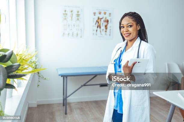 Portrait Of Female African American Doctor Standing In Her Office At Clinic Stock Photo - Download Image Now
