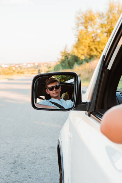 istock young handsome confident man driving car 1418980434