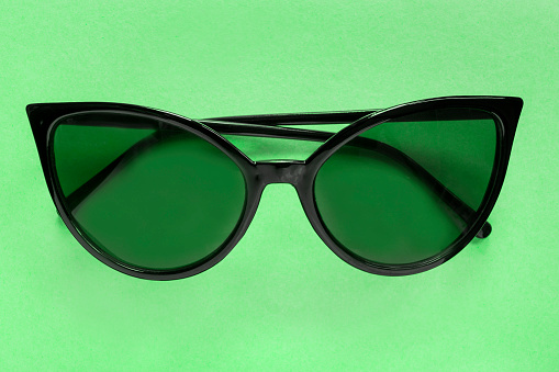 Green sunglasses on green background