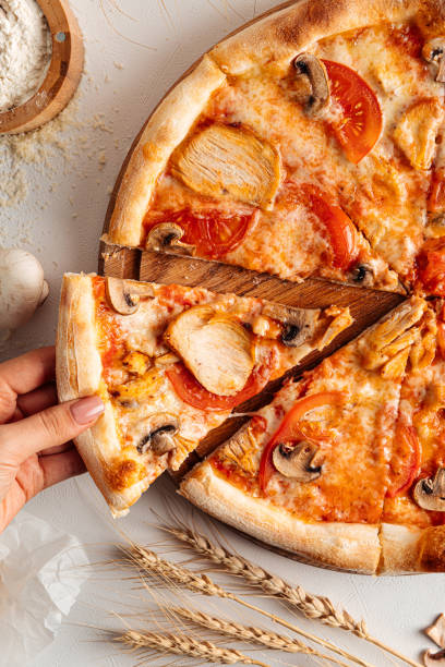 istock Taking a slice of fresh baked chicken pizza 1418985082