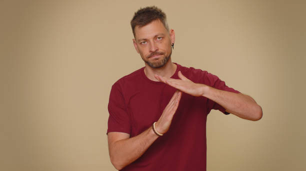 istock Time out, need a break, tired serious upset handsome young man showing pause relax gesture, stop 1418985605