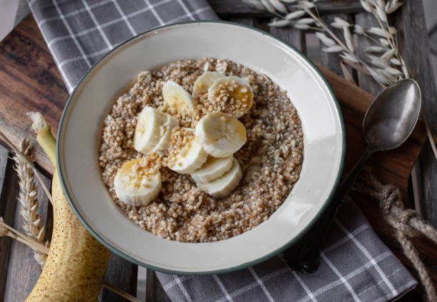 gachas de cereales para el desayuno con plátanos, nueces y jarabe de arce - quinoa spoon wood photography fotografías e imágenes de stock