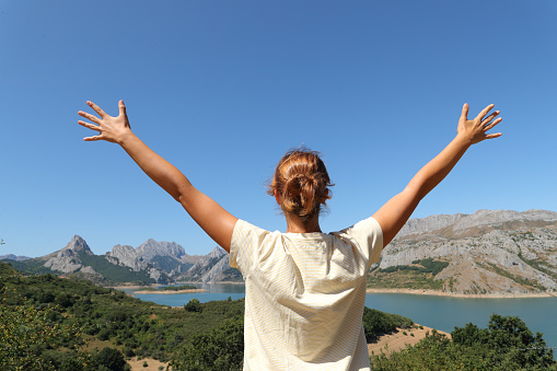 Happy woman celebrating holiday in a mountain landscape