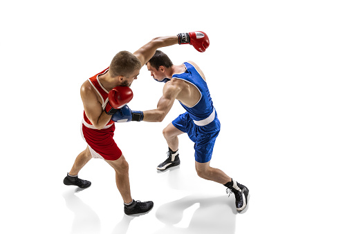Fight. Professional male boxer in sports uniform and gloves training isolated on white background. Concept of sport, competition, training, energy. Copy space for ad, text