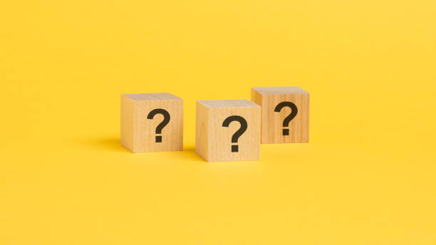 istock front view on wood cubes with black question marks. many question arising concept, yellow background 1418992192