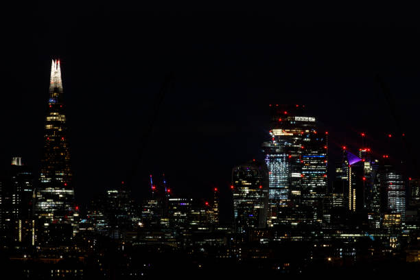 The City of London at night Scenic view of the City of London and the Shard at night as seen from the South. The City is the primary central business district of London and the world london gherkin at night stock pictures, royalty-free photos & images