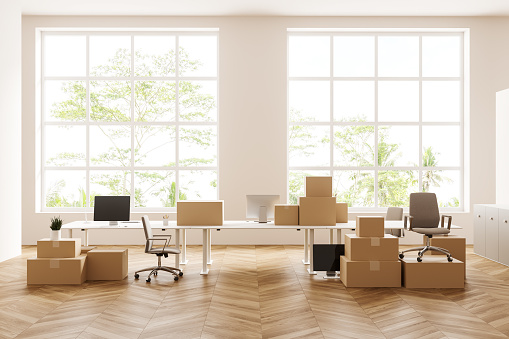 White meeting room interior with moving boxes on board, armchair and pc computer, hardwood floor. Panoramic window on tropics. 3D rendering