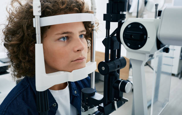 vérification de la vue du garçon avec une lampe à fente binoculaire, gros plan. correction de la vue chez les enfants - animal retina photos et images de collection