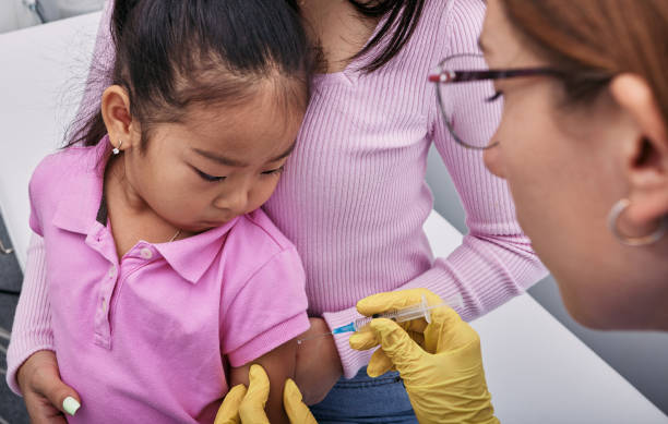 vaccinazioni di routine per il bambino. ragazza asiatica e sua madre mentre sono vaccinate dal medico generico nella clinica medica - vaccino antipolio foto e immagini stock