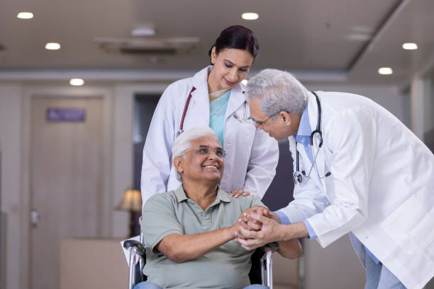 Doctors comforting disabled elderly patient. Doctors comforting disabled elderly patient at hospital medical supplies wheelchair medical equipment nursing home stock pictures, royalty-free photos & images