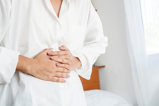 closeup woman having digestive system hand holding stomach pain