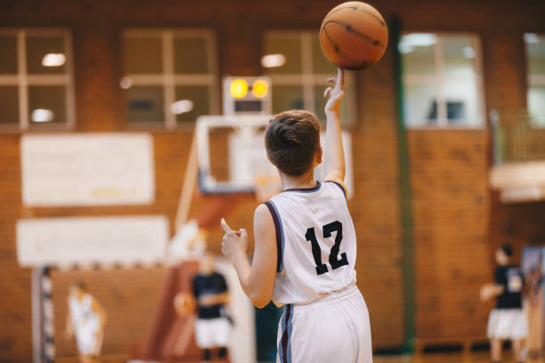 Boy Playing With Basketball on Training Session. Happy Kids on Basketball Training Practice. Group of School Basketball Players Having Fun