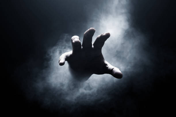 暗い背景に人間の手 - horror spooky shock zombie ストックフォトと画像